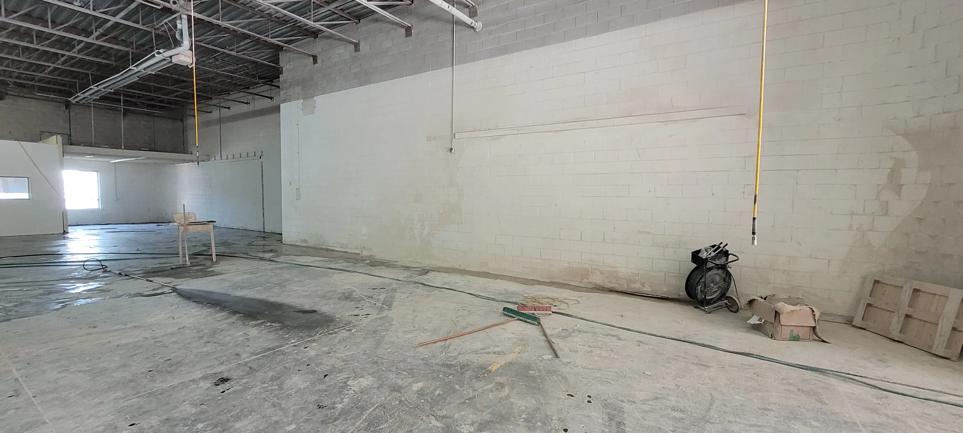 Ace Power Washing: Photo of a dirty, dusty industrial warehouse floor requiring deep cleaning