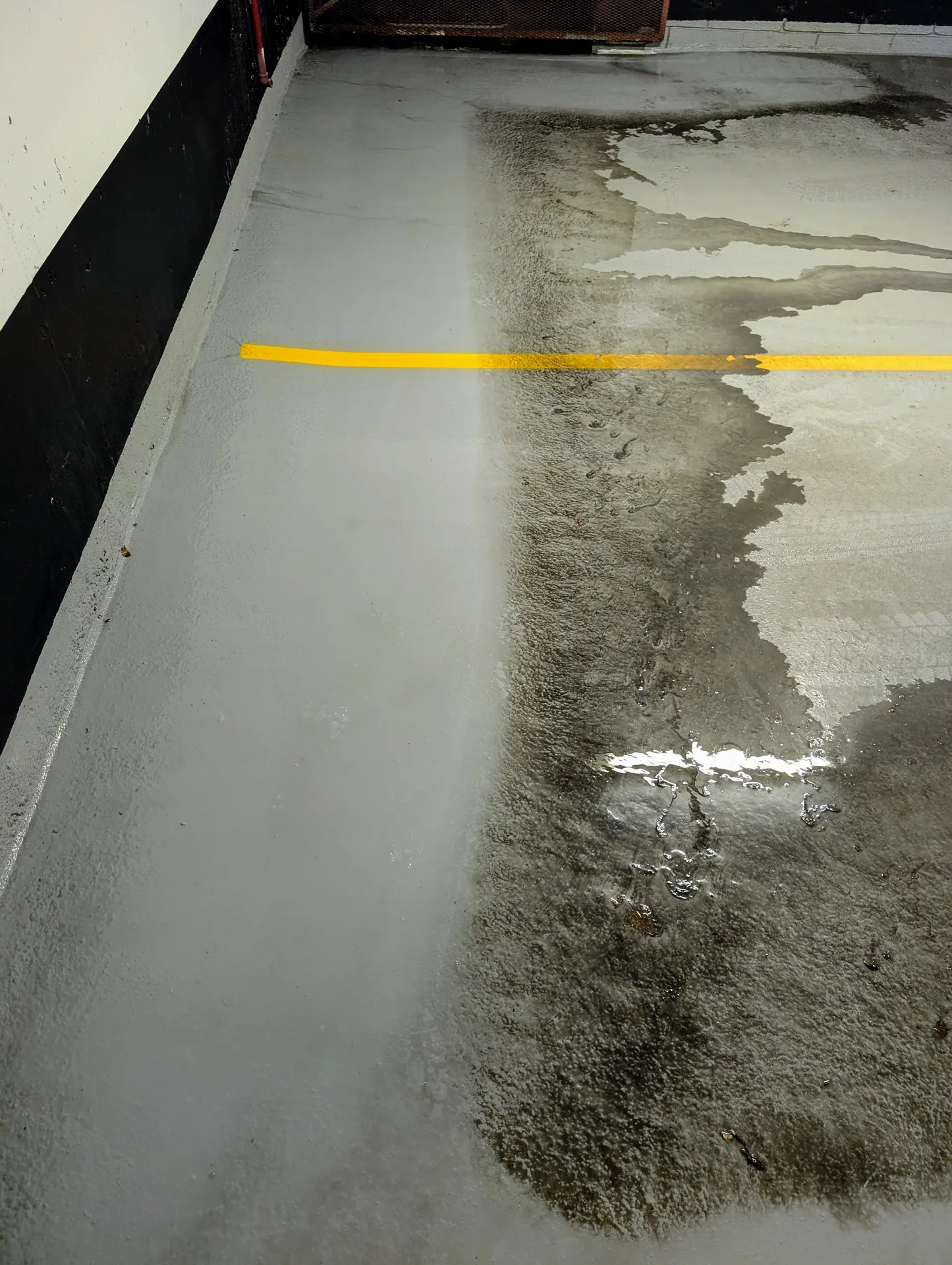 Deep cleaning of an industrial garage floor showing the removal of heavy oil from epoxy floor and tire marks