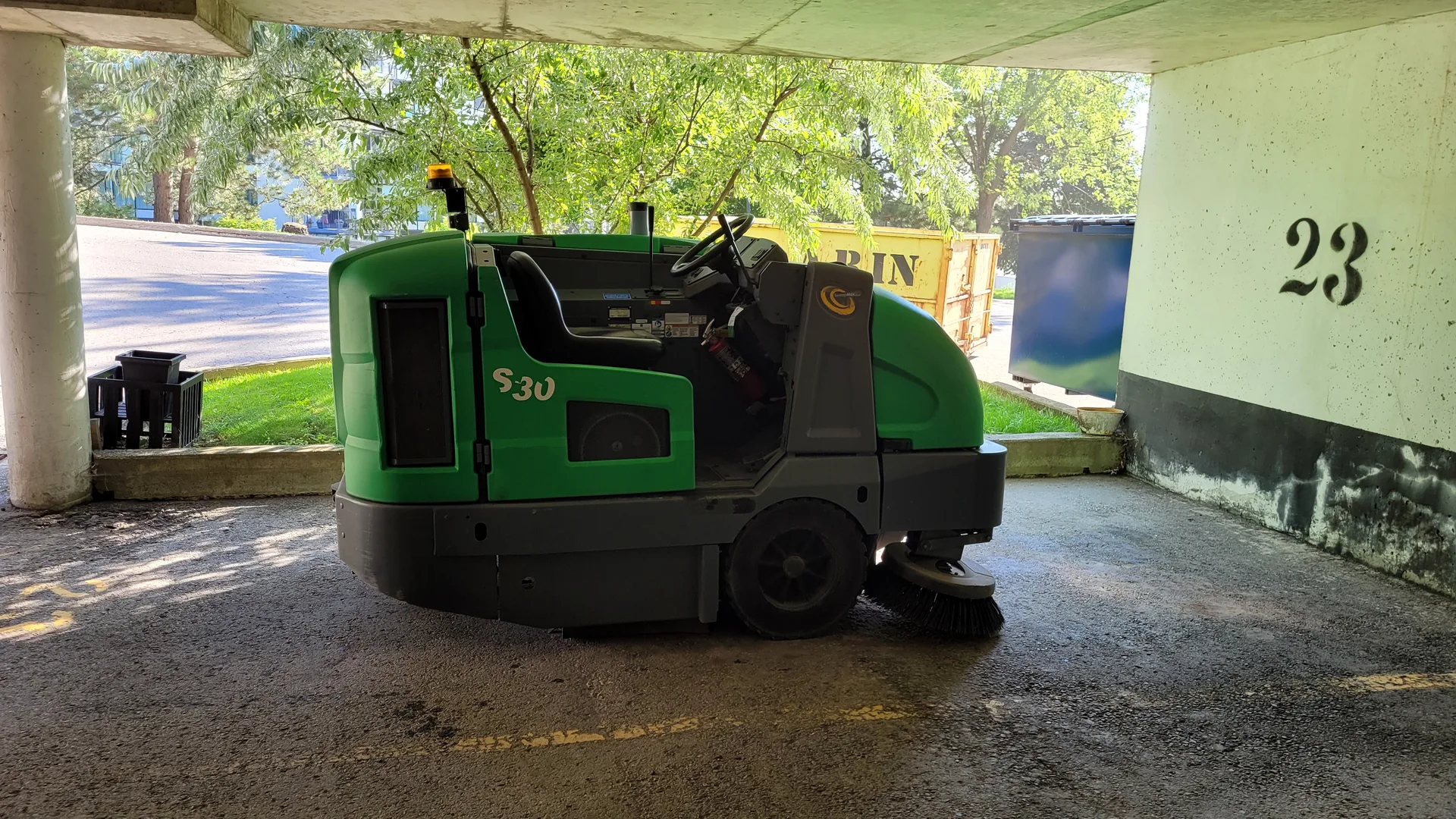 Commercial parking garage floor power sweeping equipment in action
