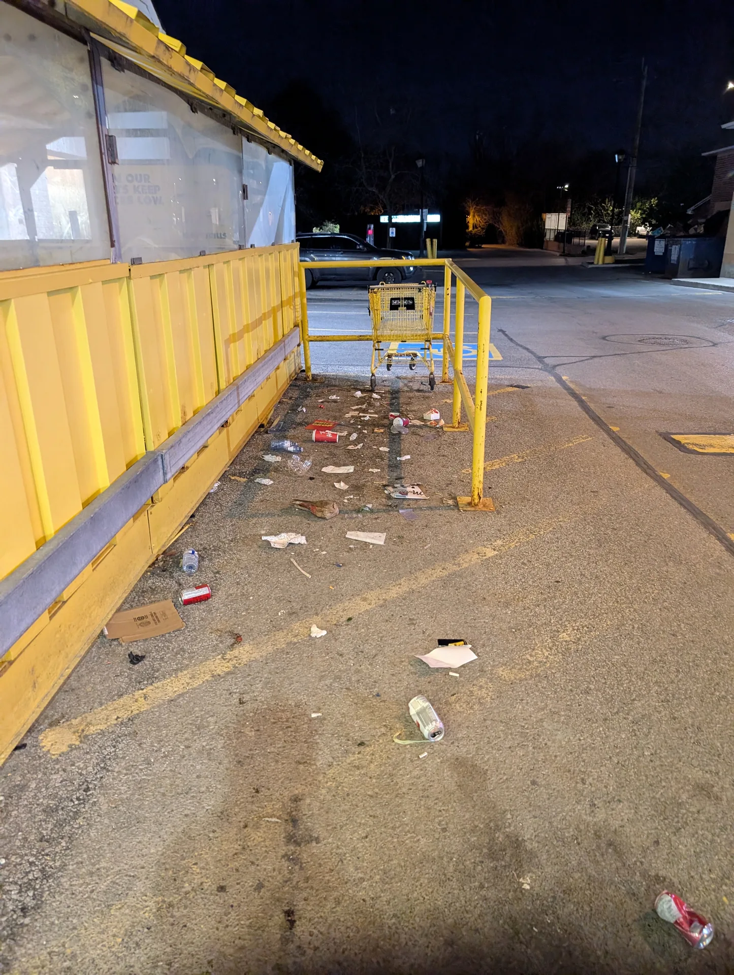 Neglected commercial parking lot with scattered garbage and cans before professional cleanup