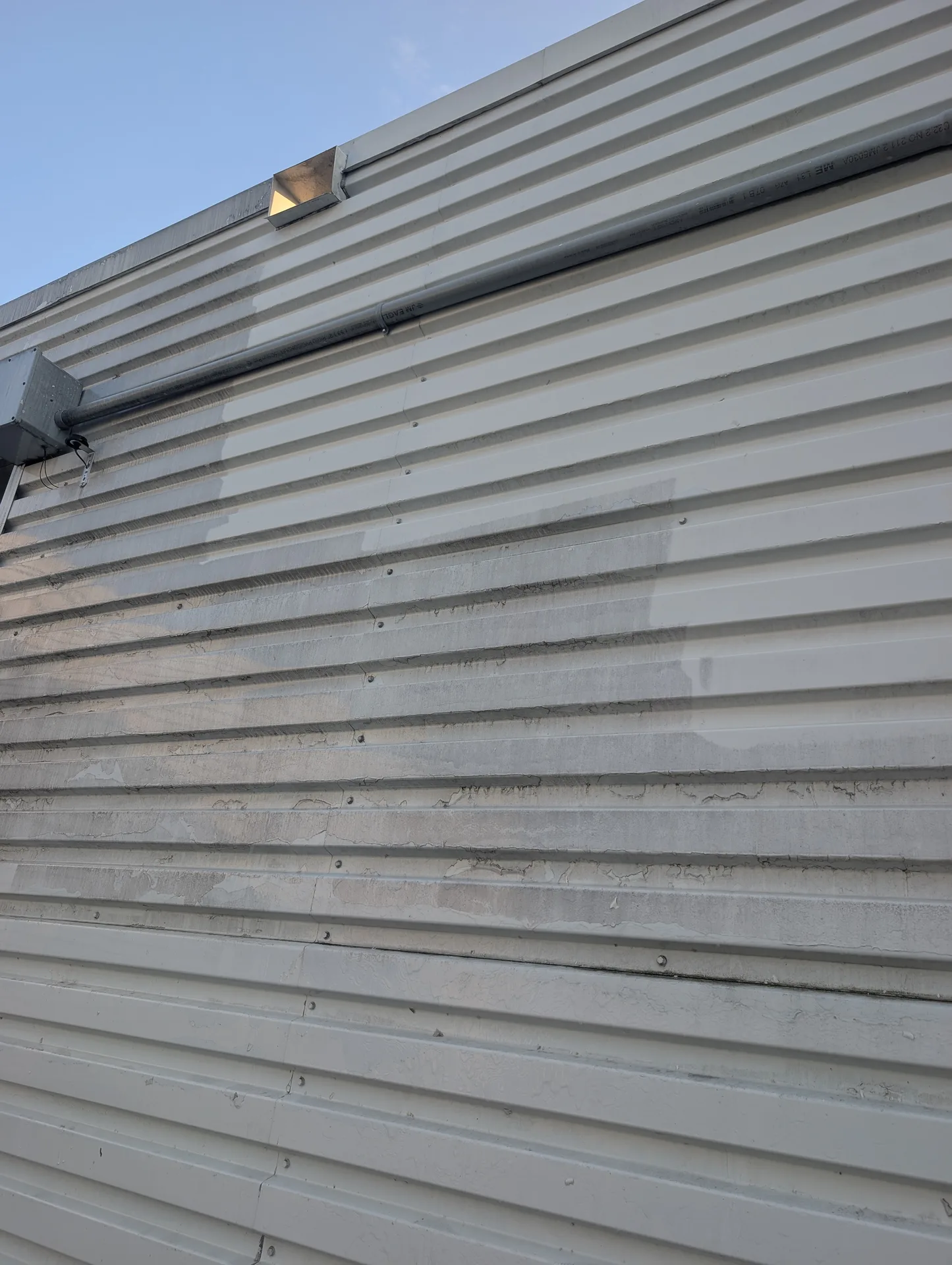 Industrial metal cladding and concrete foundation cleaning by Ace Power Washing for property managers