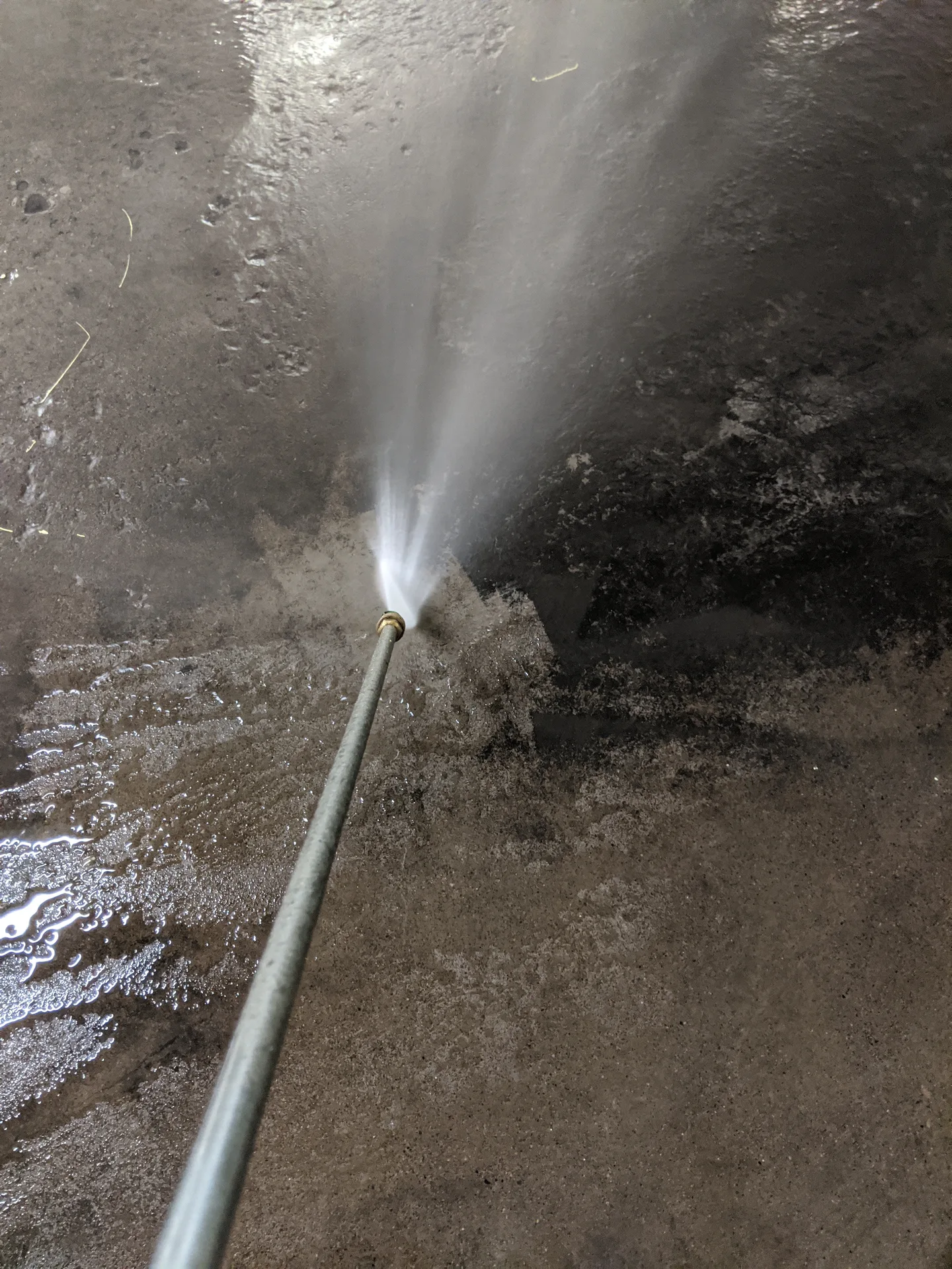 Pressure washing effectively removing deep-seated oil residue from a commercial floor