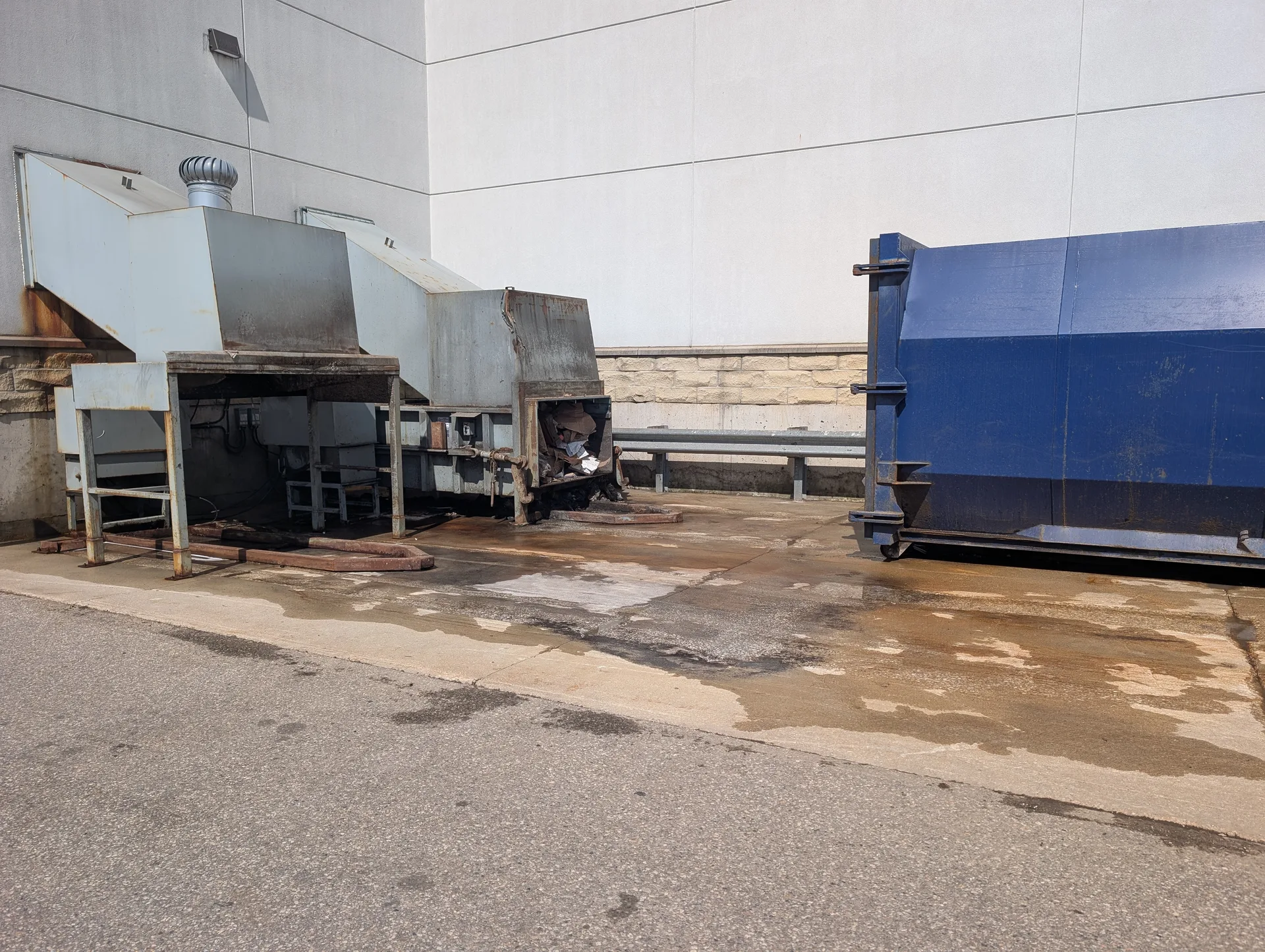 Cleaned commercial waste disposal area following professional degreasing and pressure washing services