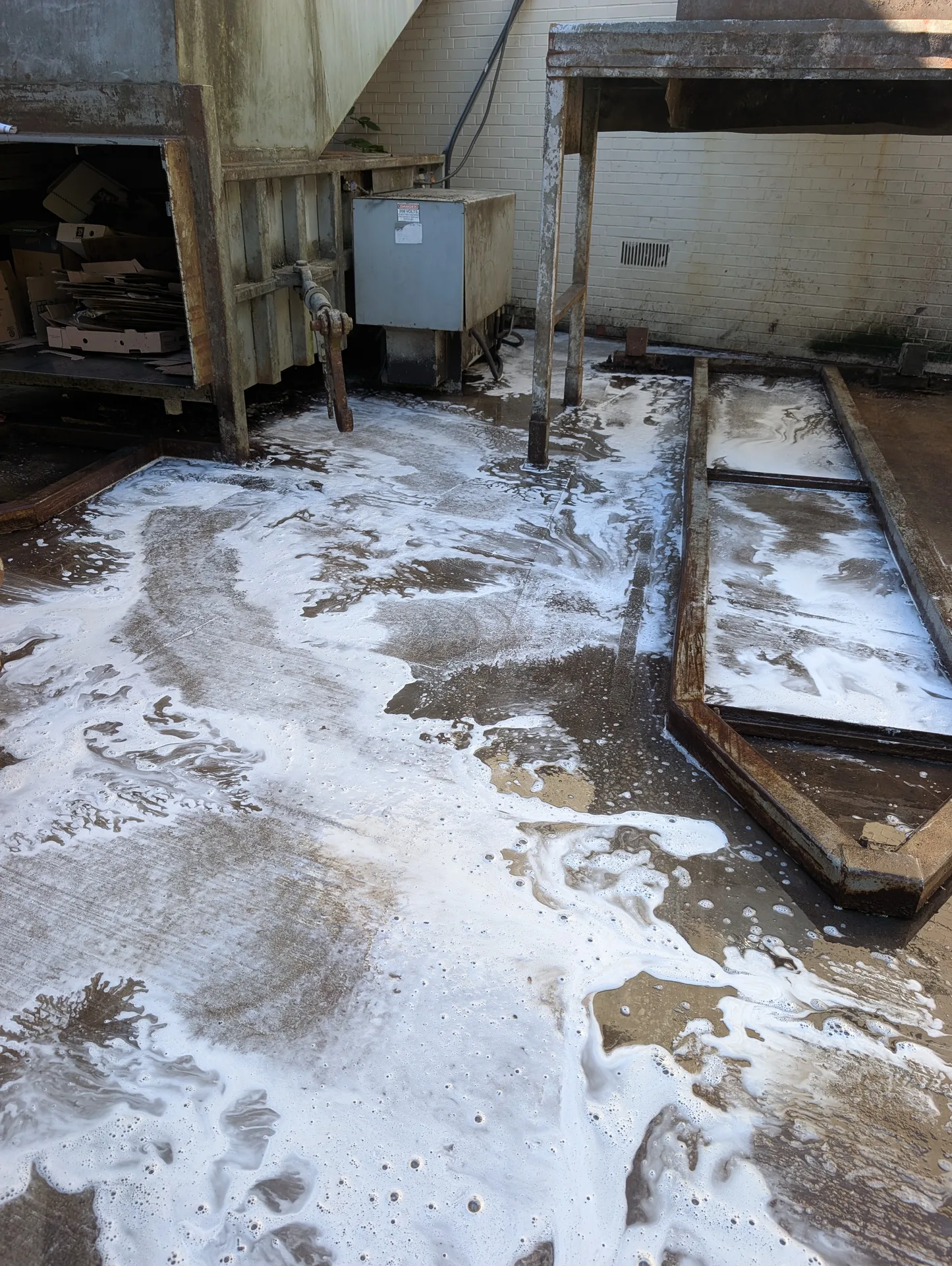 Professional compactor pad degreasing by Ace Power Washing to eliminate odors and pest attractants