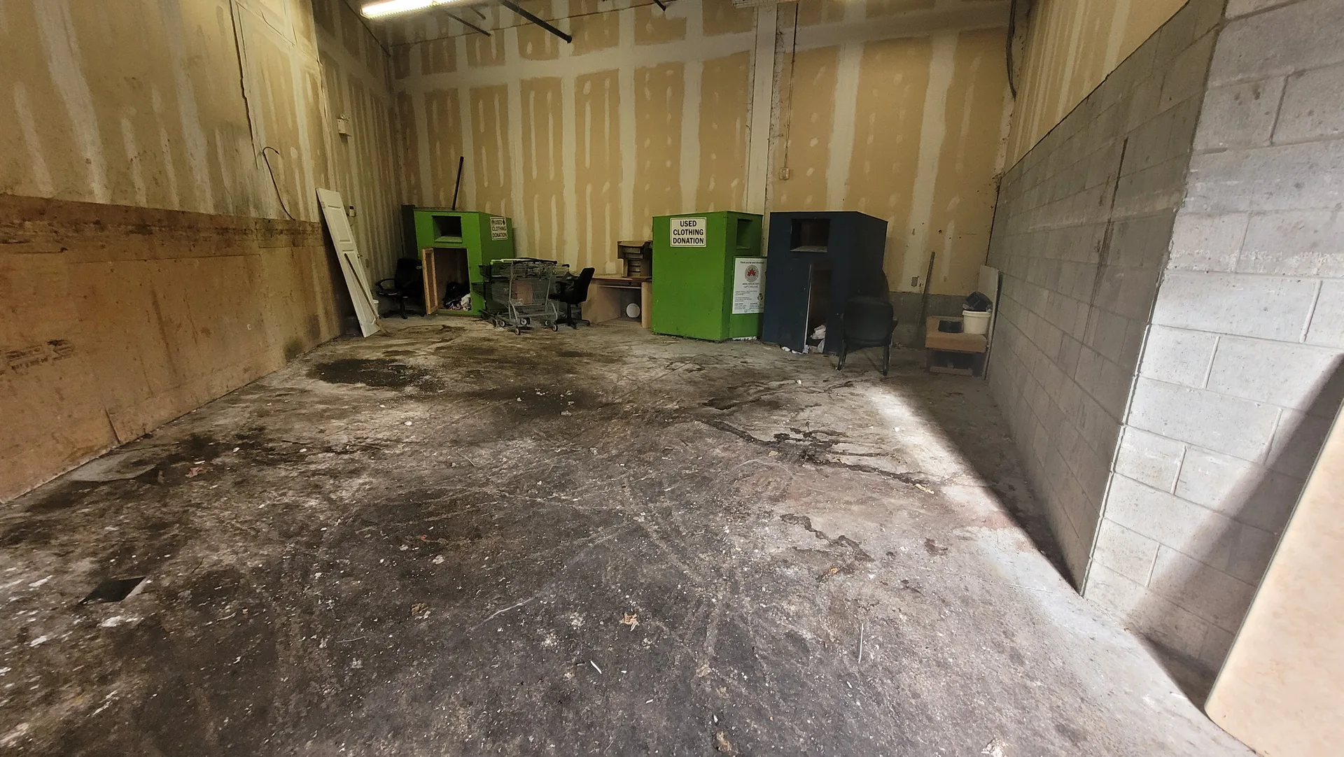 Neglected commercial garbage room significant floor staining and grime before industrial-grade power scrubbing and sanitation