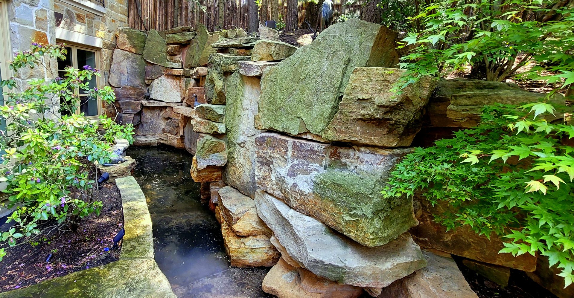 Green algae and moss accumulation on an estate stone waterfall and fountain in York prior to ACE chemical treatment